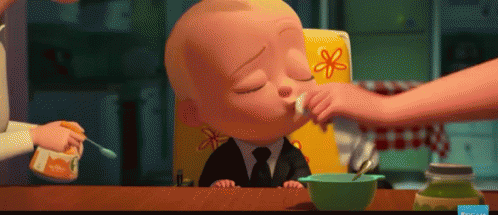 A Baby In A High Chair Is Being Fed With A Spoon . GIF