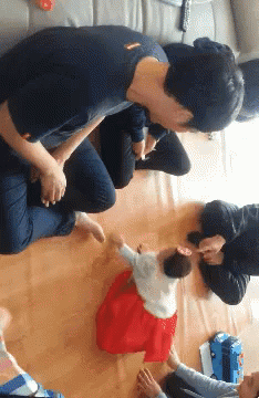 Baby In Red Dress Held By Man GIF
