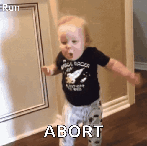A Baby In A Space Racer Shirt Is Dancing In A Hallway With The Word Abort In The Corner . GIF