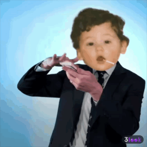 A Baby In A Suit And Tie Is Holding A Cell Phone GIF