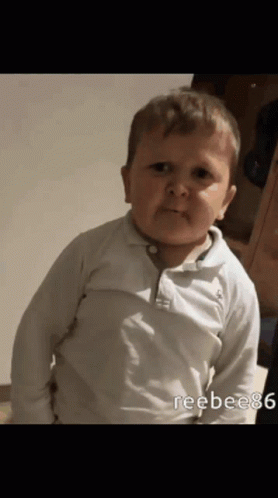 A Baby In A White Shirt Is Making A Face GIF