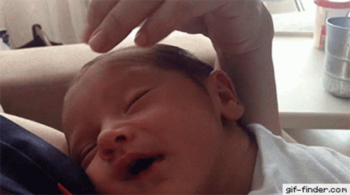 A Baby Is Being Held By A Person With A Gif-Finder.com Watermark On The Bottom Right GIF