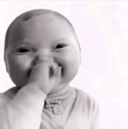 A Baby Is Covering His Mouth With His Hand GIF