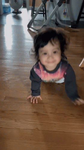 A Baby Is Crawling On The Floor Wearing A Shirt That Says ' Spiderman ' On It GIF
