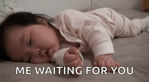 A Baby Is Laying On A Bed With The Words " Me Waiting For You " Written Above It GIF