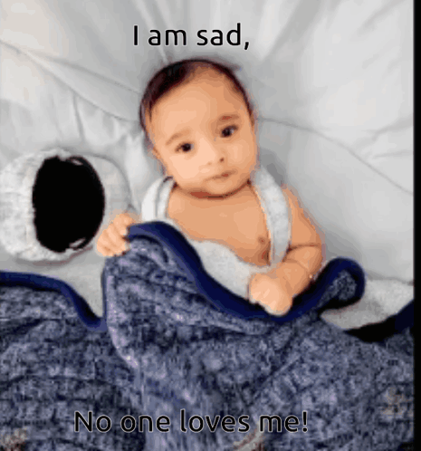A Baby Is Laying Under A Blanket With The Caption I Am Sad GIF