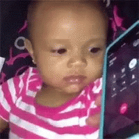 A Baby Is Looking At A Tablet Computer . GIF