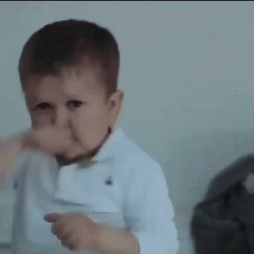 A Baby Is Making A Funny Face And Giving A Thumbs Up Sign . GIF