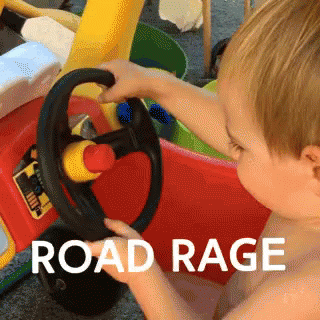 A Baby Is Playing With A Toy Car With The Words Road Rage Written On The Bottom GIF