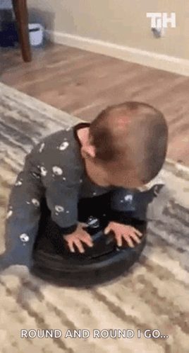 A Baby Is Playing With A Vacuum Cleaner On A Carpet . GIF