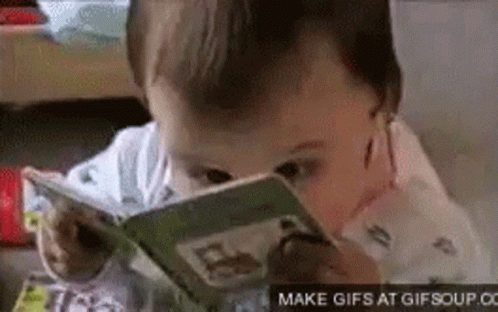 A Baby Is Reading A Book With A Magnifying Glass On His Face . GIF