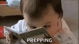 A Baby Is Reading A Book With The Word Prepping Written Next To Him . GIF