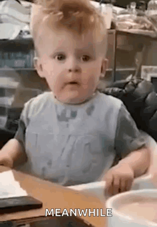 A Baby Is Sitting In A High Chair At A Table With A Bowl Of Food . GIF