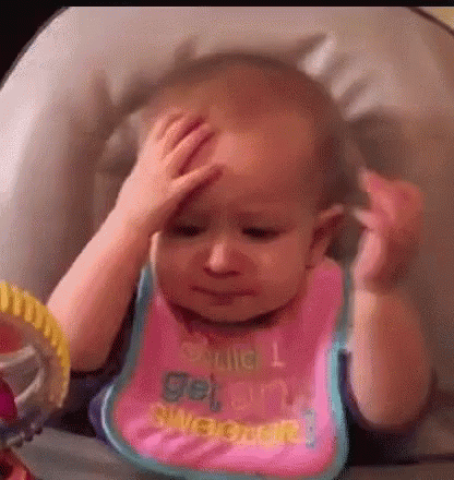 A Baby Is Sitting In A High Chair Holding Her Head . GIF