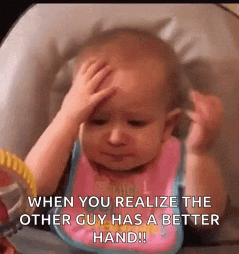 A Baby Is Sitting In A High Chair Holding His Head And Looking At Himself In A Mirror . GIF
