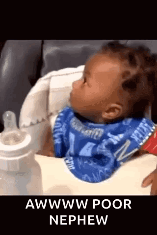 A Baby Is Sitting In A High Chair Next To A Bottle And A Bib . GIF