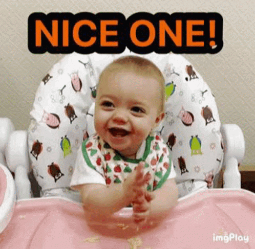 a baby is sitting in a high chair smiling and clapping .