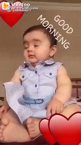 A Baby Is Sitting On A Bed With A Good Morning Message GIF