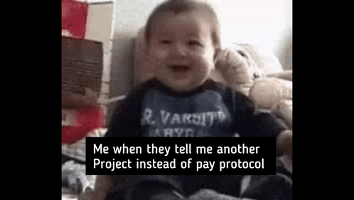 A Baby Is Sitting On A Bed With A Teddy Bear . GIF