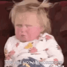 A Baby Is Sitting On A Couch And Making A Face . GIF