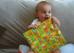 A Baby Is Sitting On A Couch Holding A Happy Birthday Gift GIF