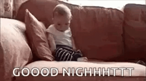 A Baby Is Sitting On A Couch With The Words `` Good Night '' Written On The Couch . GIF