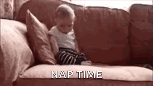 A Baby Is Sitting On A Couch With The Words `` Nap Time '' Written Above Him . GIF
