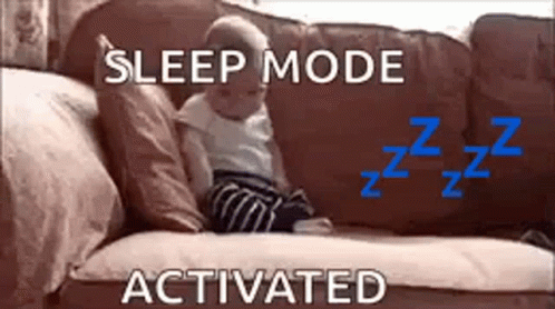 A Baby Is Sitting On A Couch With The Words `` Sleep Mode Activated '' Above It . GIF