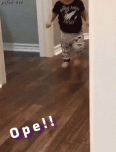 A Baby Is Walking On A Wooden Floor And The Word Ope Is On The Floor GIF