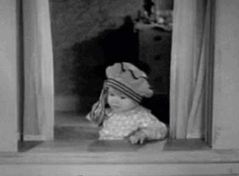 A Baby Is Wearing A Hat And Looking Out Of A Window . GIF