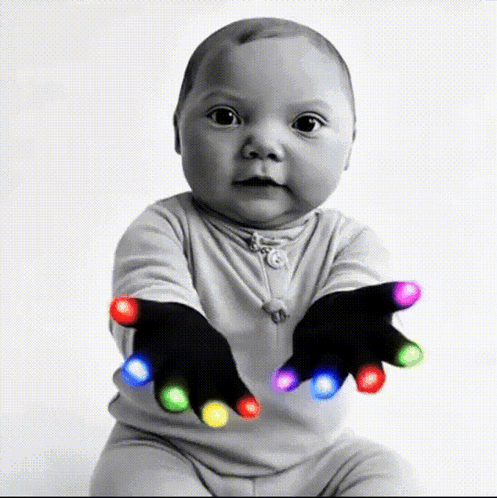 A Baby Is Wearing A Pair Of Black Gloves With Colorful Lights On Them GIF