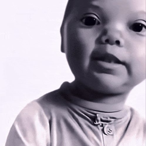 A Baby Is Wearing A White Shirt With A Zipper On The Front GIF