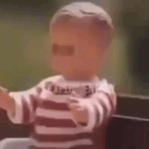A Baby Is Wearing Sunglasses And A Striped Shirt And Is Sitting On A Bench . GIF