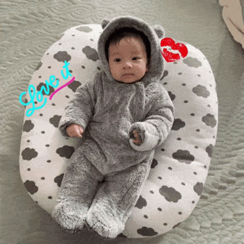 A Baby Laying On A Pillow That Says Love It On It GIF