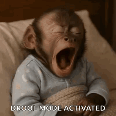 a baby monkey is yawning while laying in a bed .