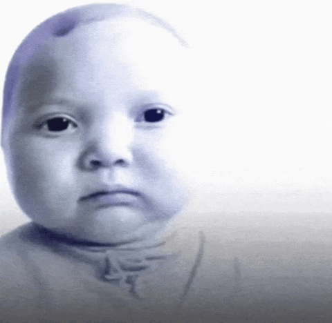 A Baby 'S Face Is Shown With A Serious Look On His Face GIF