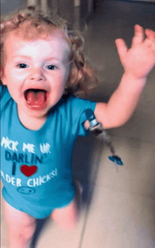 A Baby Wearing A Blue Shirt That Says " Pick Me Up Darlin " On It GIF