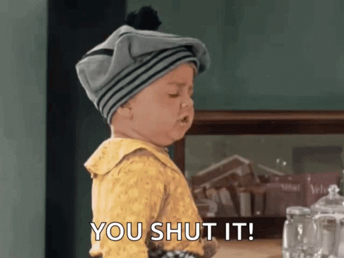 A Baby Wearing A Gray Hat And A Yellow Shirt Says You Shut It GIF