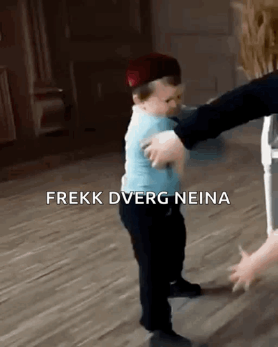 A Baby Wearing A Hat Is Being Held By A Person . GIF