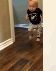 A Baby Wearing A Shirt That Says Space Racer GIF
