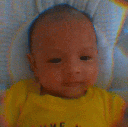 A Baby Wearing A Yellow Shirt That Says Love GIF