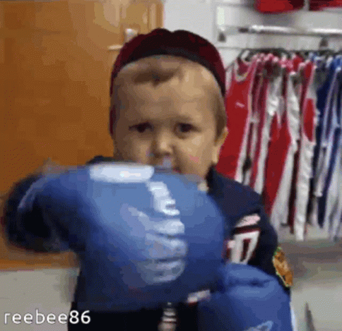 A Baby Wearing Blue Boxing Gloves With The Number 17 On Them GIF