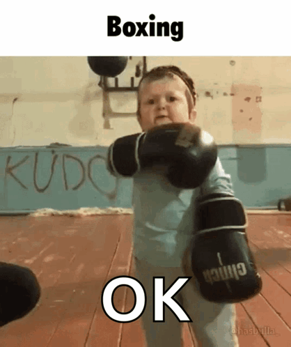 A Baby Wearing Boxing Gloves With The Word Ok Underneath GIF
