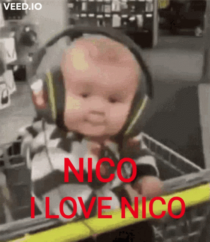 A Baby Wearing Headphones Is Sitting In A Shopping Cart With The Words " Nico I Love Nico " On It GIF