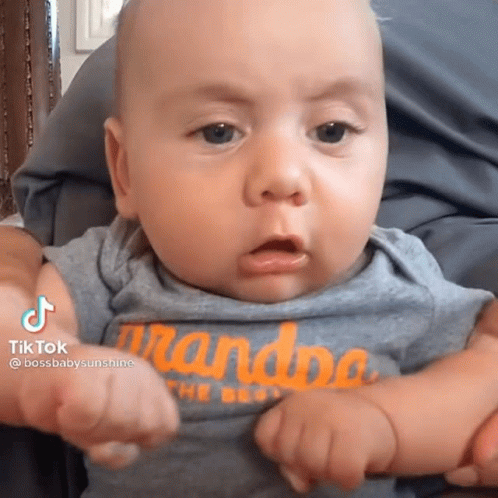 a baby with a shirt that says grandpa on it