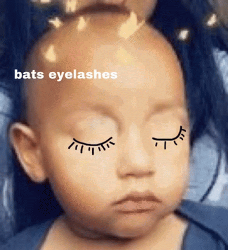 A Baby With Closed Eyes Has Bats Eyelashes On His Face GIF