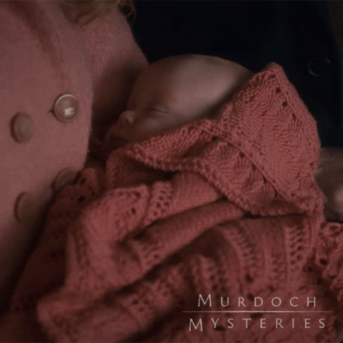 A Baby Wrapped In A Pink Blanket With Murdoch Mysteries Written On The Bottom GIF