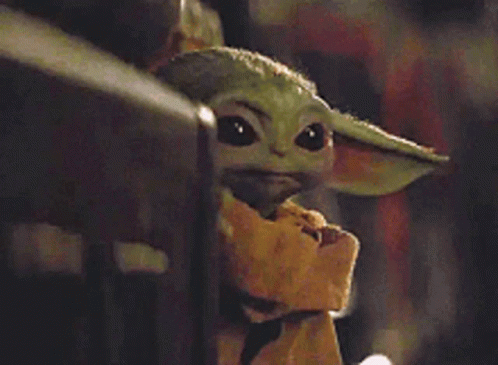 A Baby Yoda From Star Wars Is Sitting On A Fence Looking At The Camera . GIF