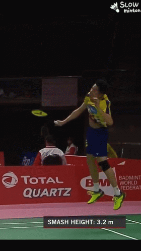 A Badminton Player Is Jumping In The Air In Front Of A Total Quartz Banner GIF