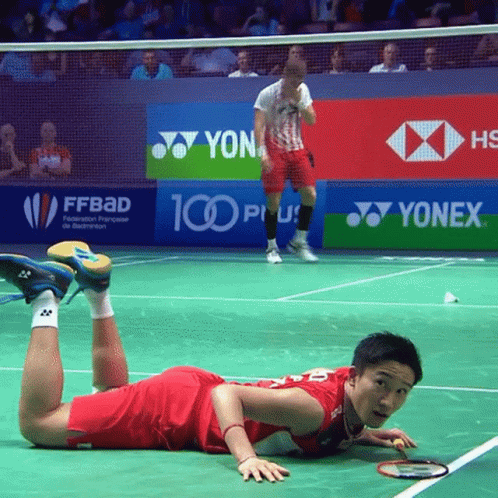 A Badminton Player Is Laying On The Court In Front Of Yonex Advertisements GIF